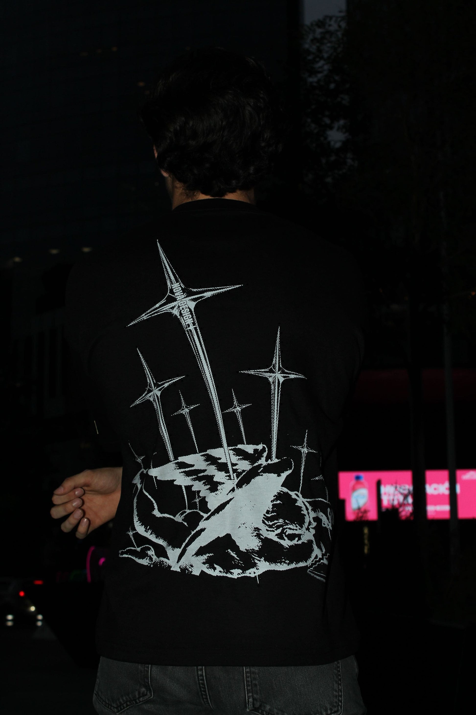 Playera oversize negra Nova Design con gráfico trasero grande de cupido caído atravesado por espadas estilo streetwear bélico
