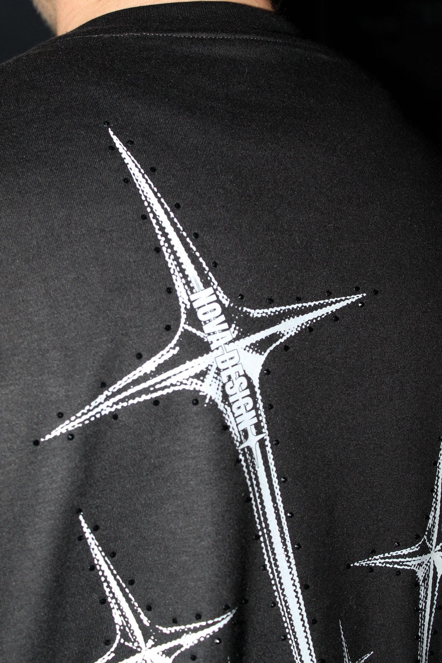 Detalle de espadas en gráfico trasero de cupido caído en playera Nova Design