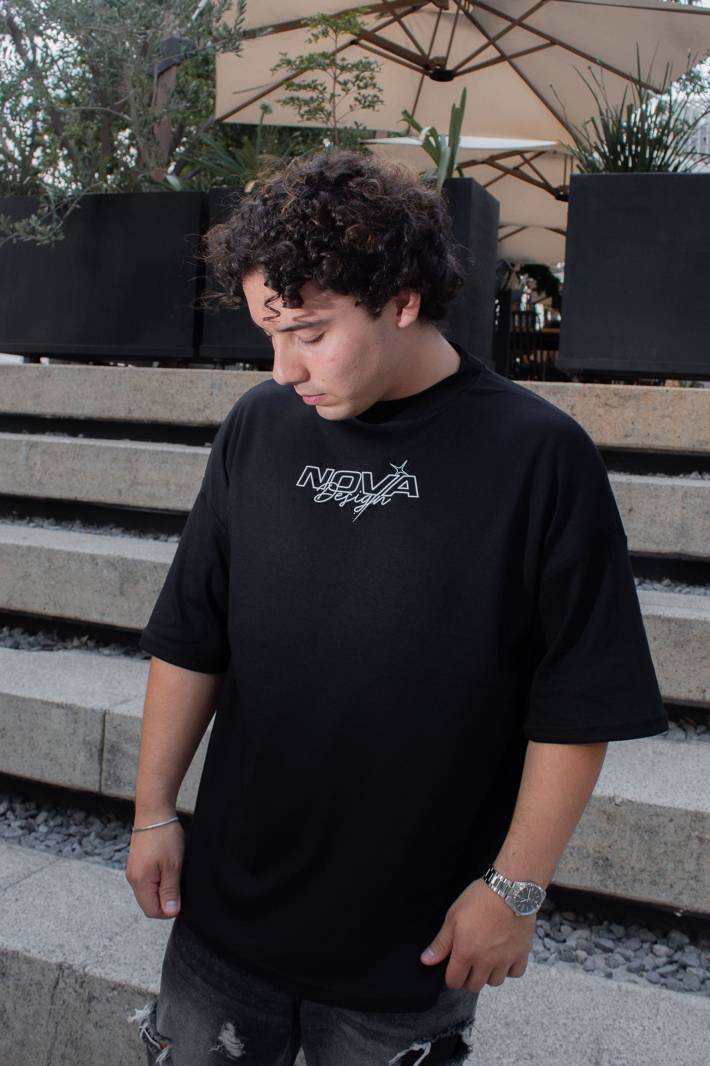 Playera streetwear negra con logo Nova Design, estrellas y pedrería discreta