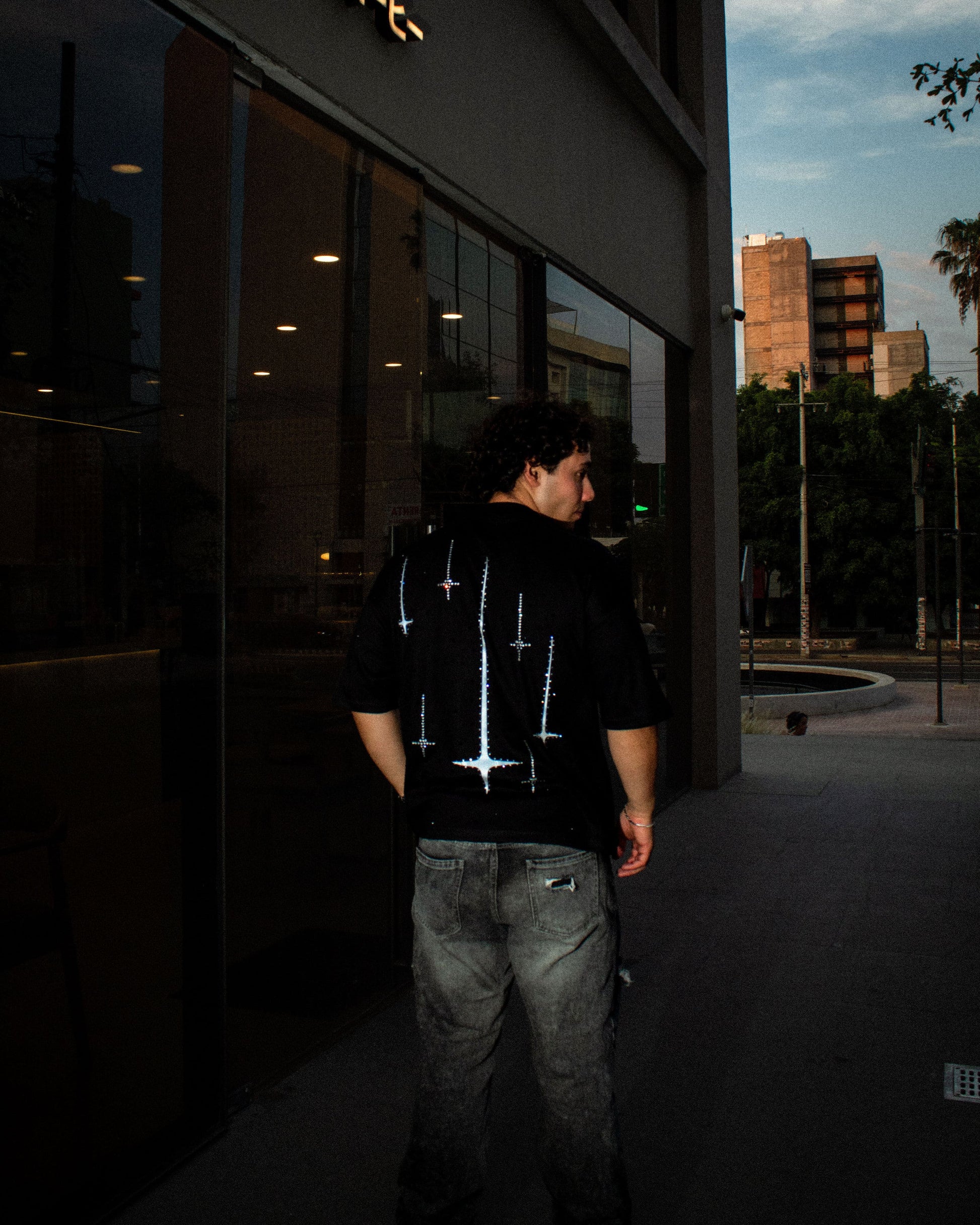 Playera oversize Nova Design con estrellas tipo destello y pedrería negra