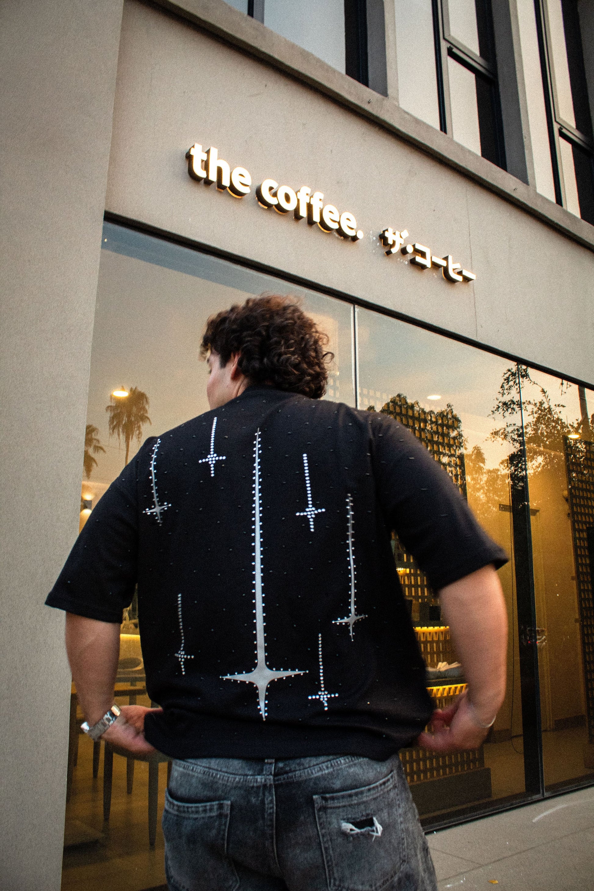 Playera Falling Stars negra corte over con diseño de estrellas y pedrería en espalda