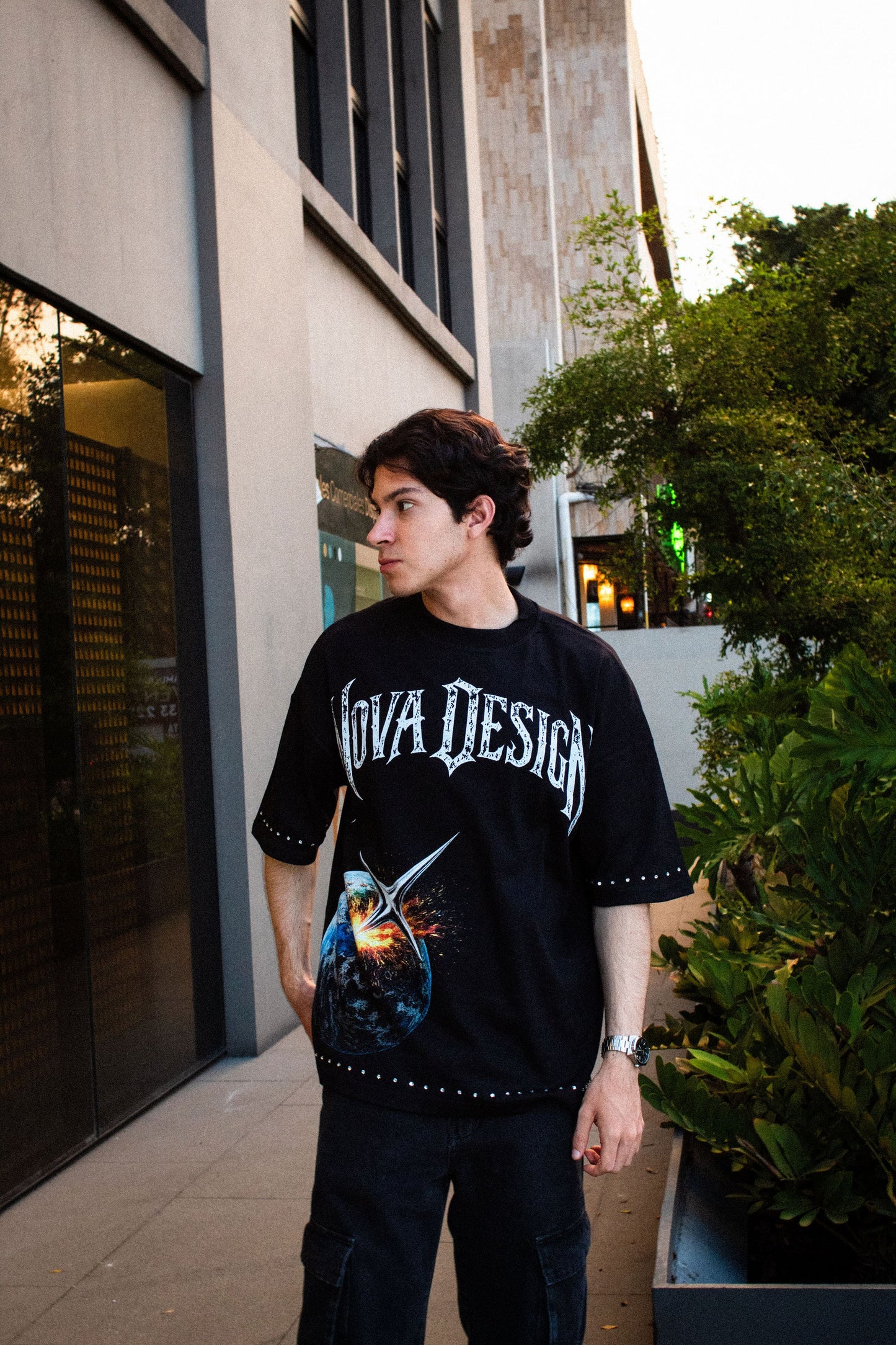 Playera streetwear negra con diseño espacial, pedrería en mangas y corte over